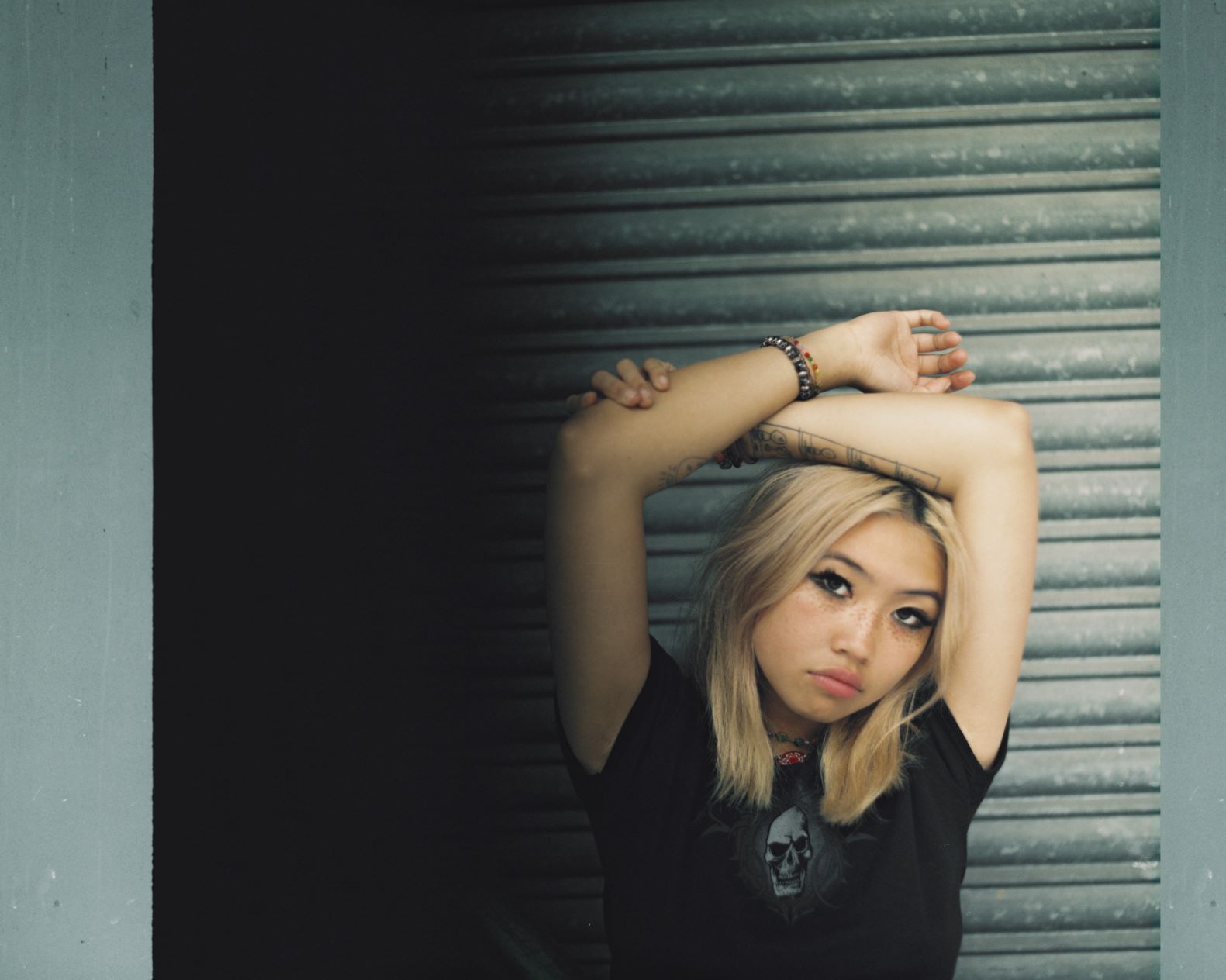 Black to grey shuttered backdrop and musician, Beabadoobee
