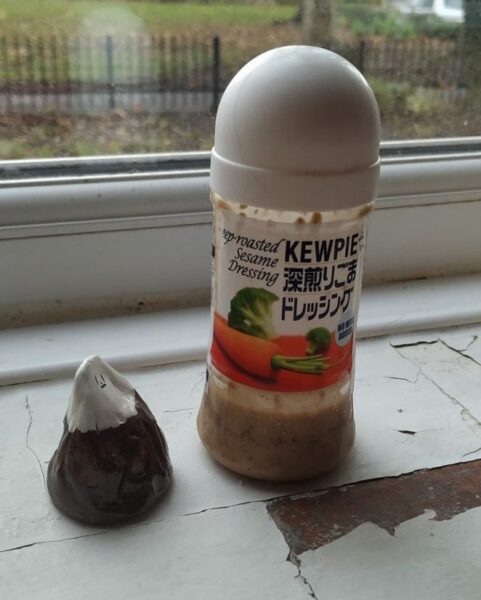 small mountain sculpture ooking up at deep-roasted sesame dressing bottle