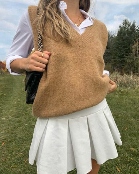Brown sweater vest with white collar and pleated skirt