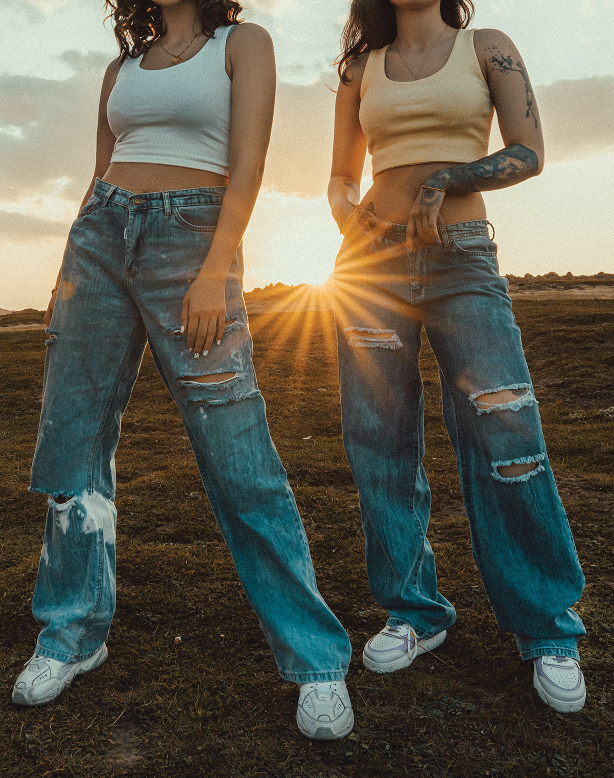 Women wearing ripped jeans and trainers