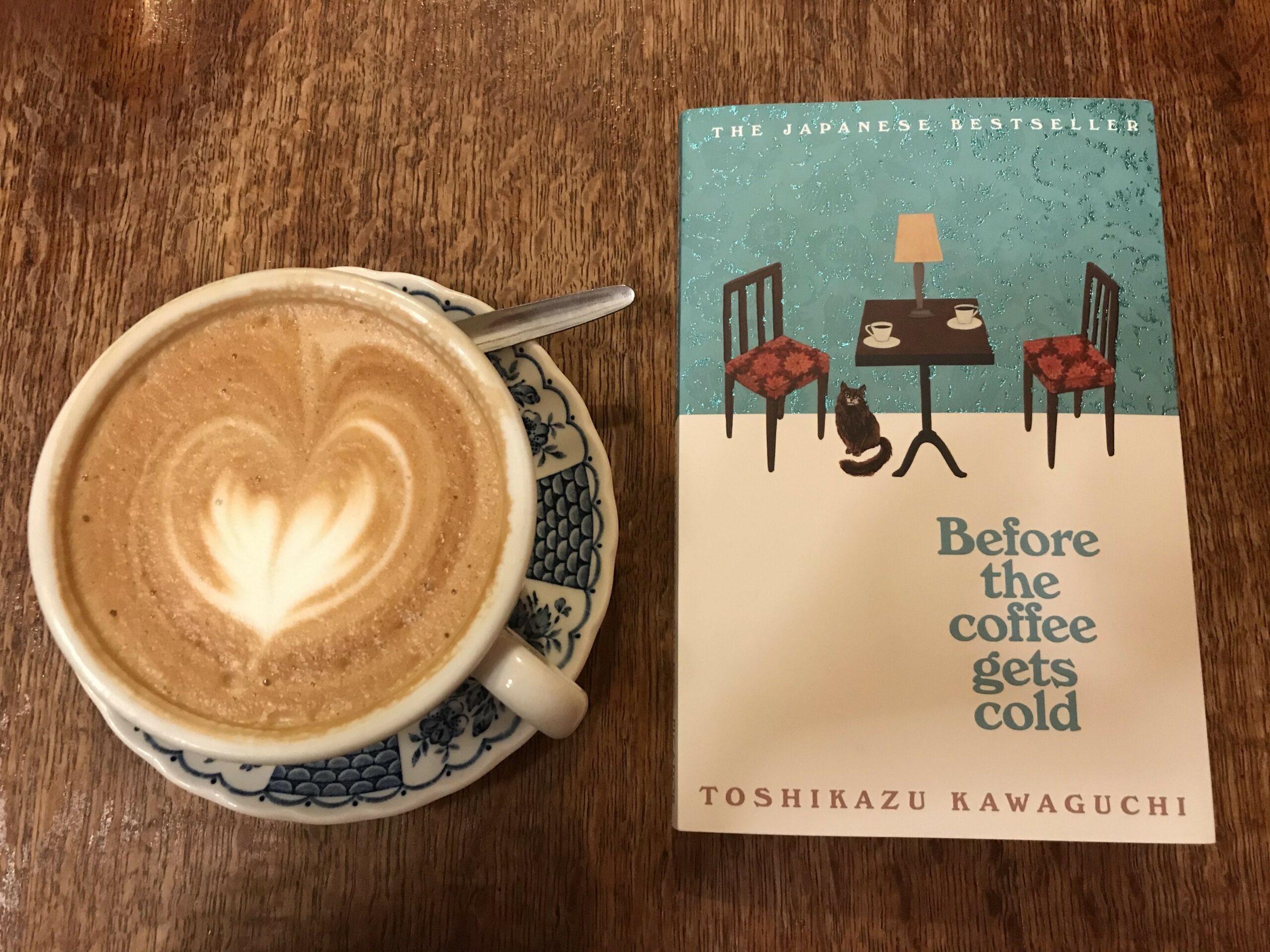 Photo of Before the Coffee Gets Cold next to a cup of coffee
