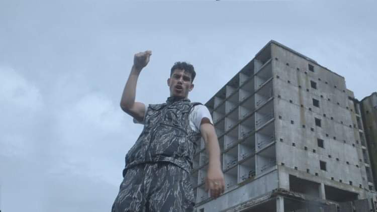 Grime artist Geoblu foreground a grey sky and skyline