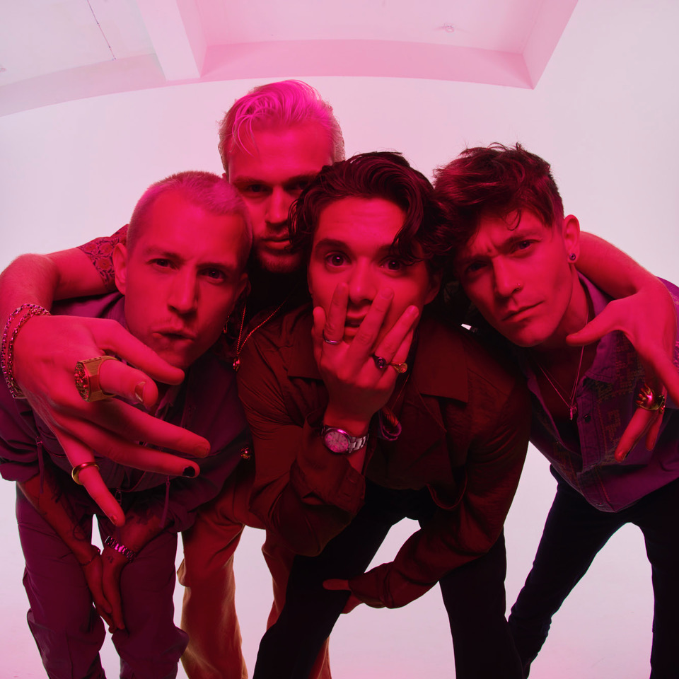 Close up image indie pop band, the vamps before pink hued backdrop