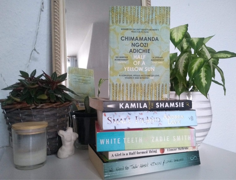 Photo of Half of a Yellow Sun on a stack of other books