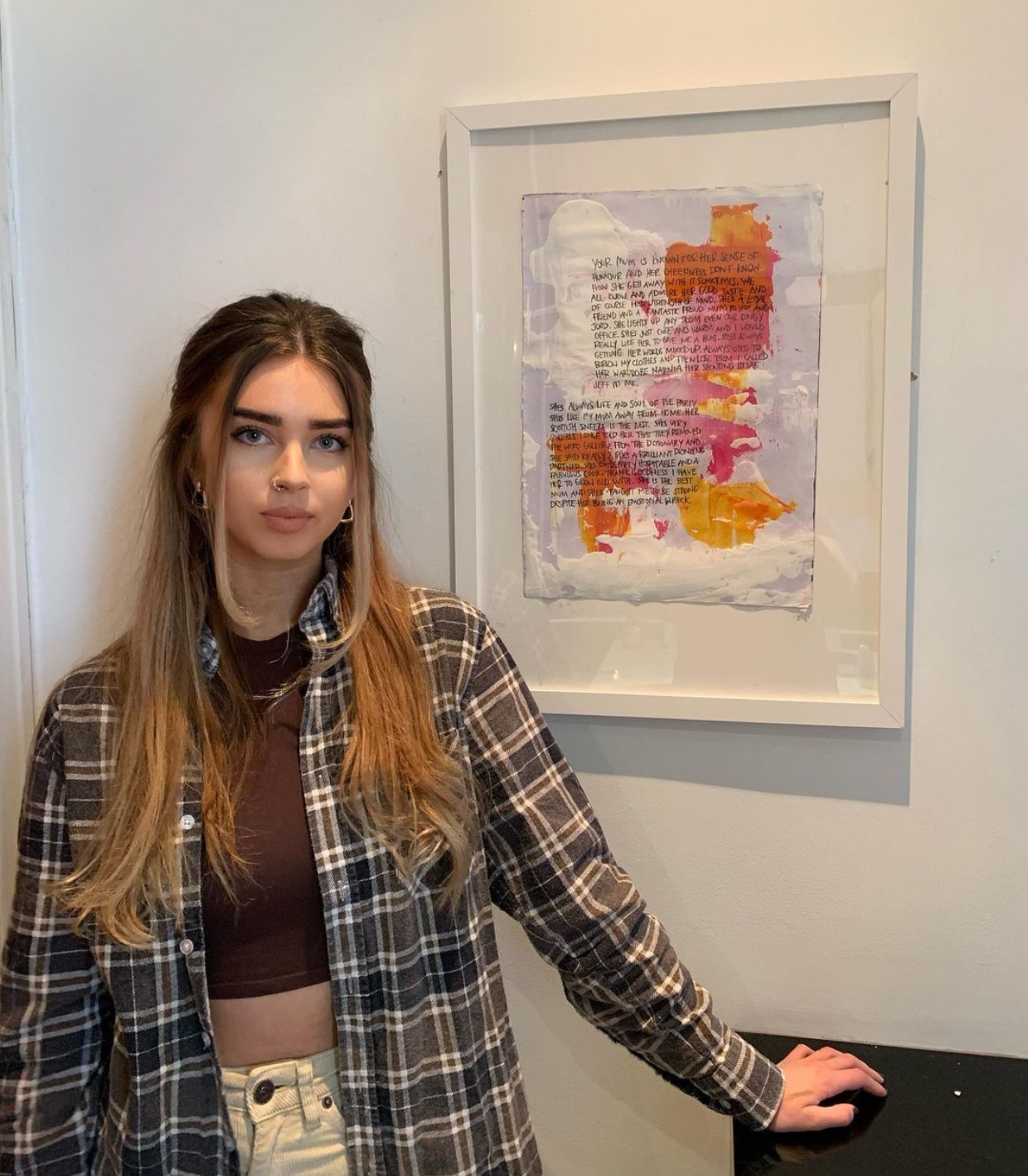 Artist Millie Roberts with a framed work
