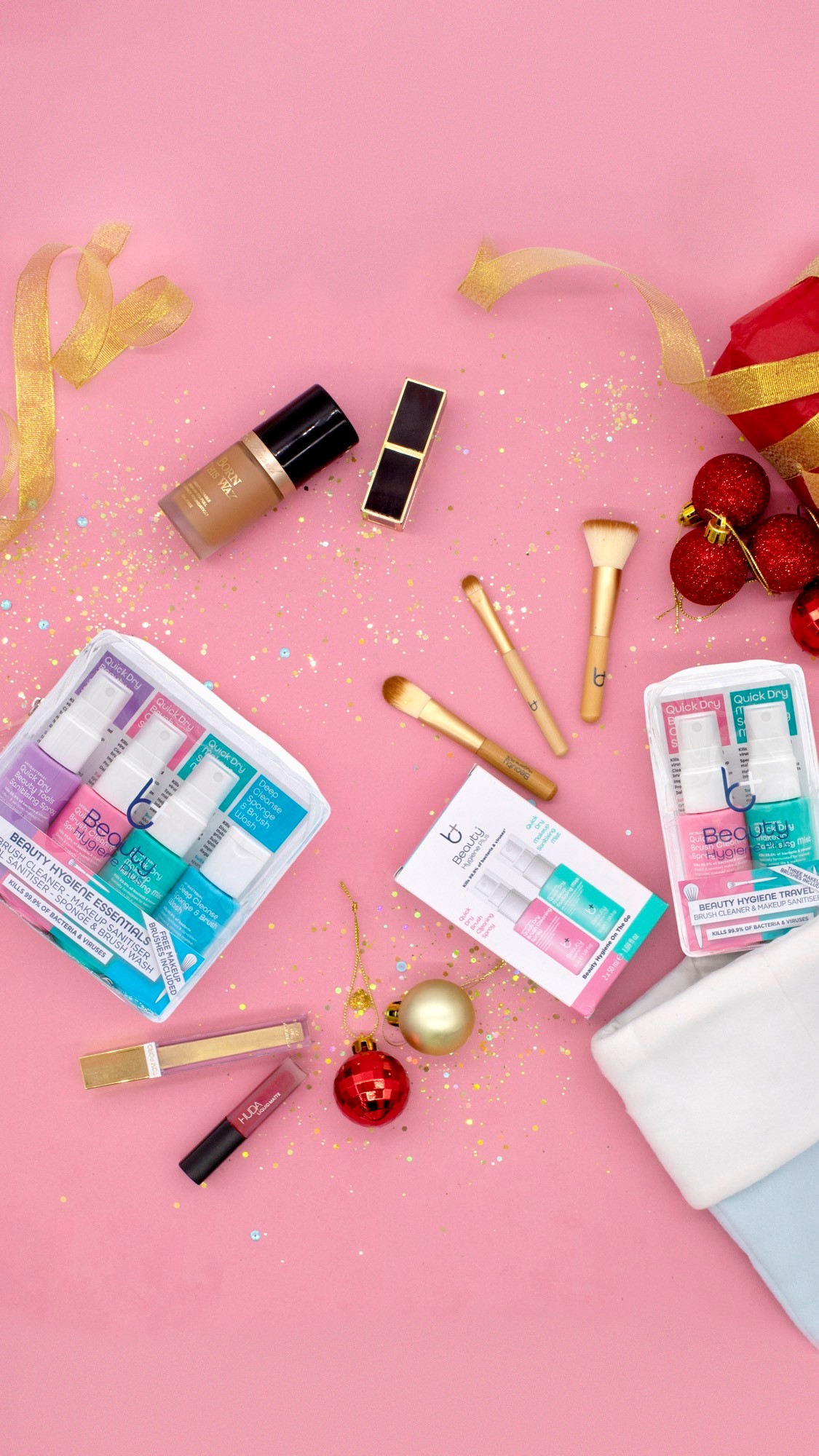 Beauty Hygiene Plus products flat lay with some beauty products and a pink background