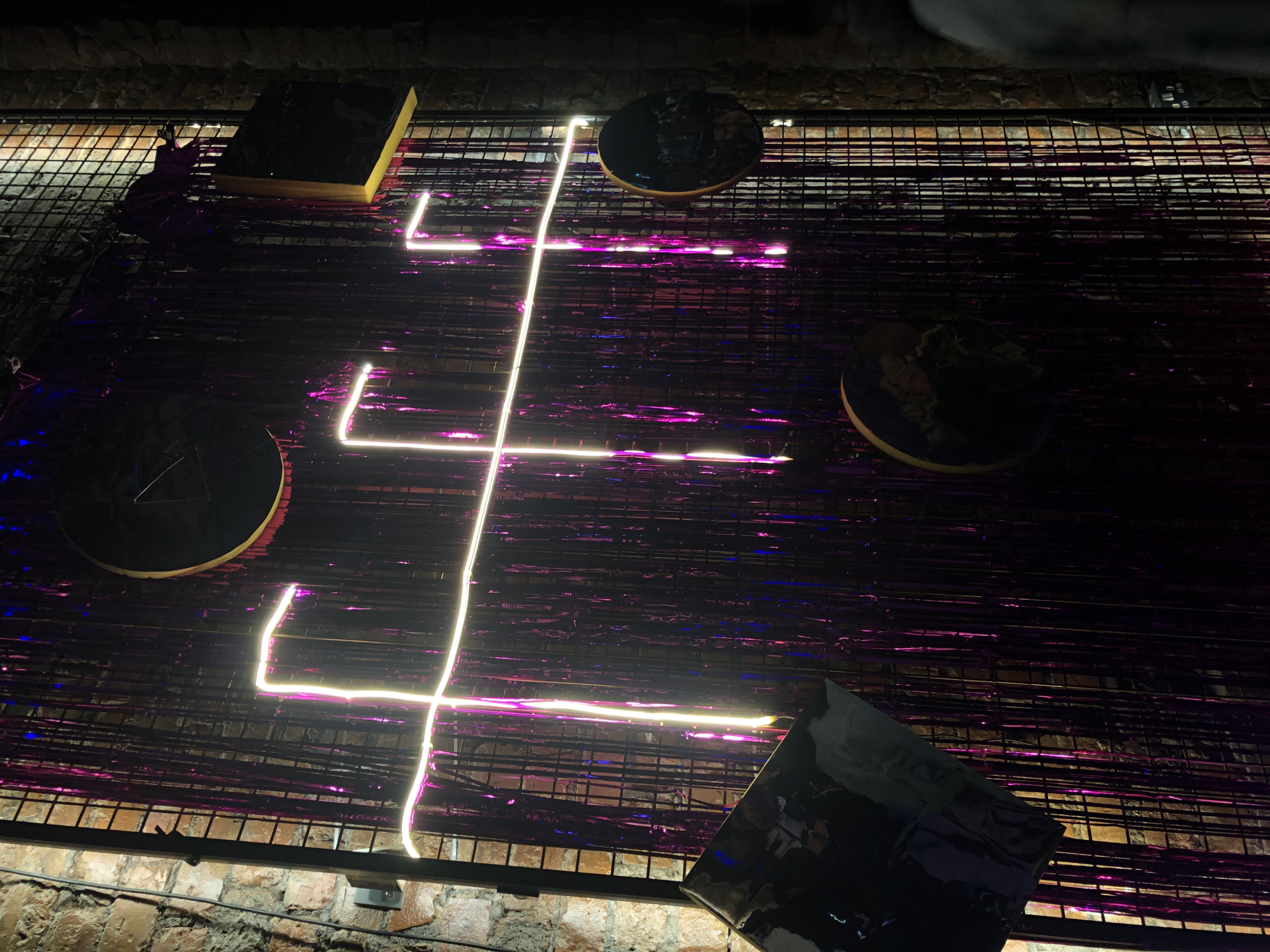FFF written in purple luminous lighting on a background of purple streamers