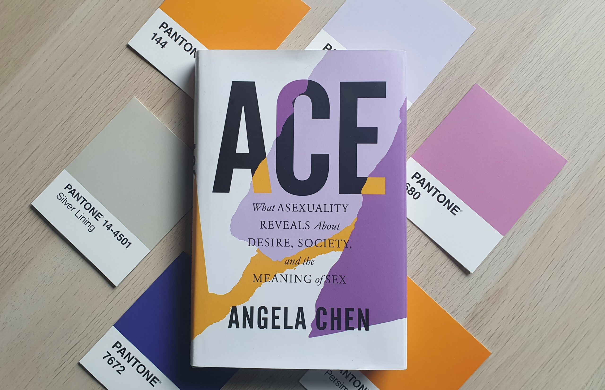 The book "Ace" laid on top of 6 Pantone postcards of similar colours to the book cover