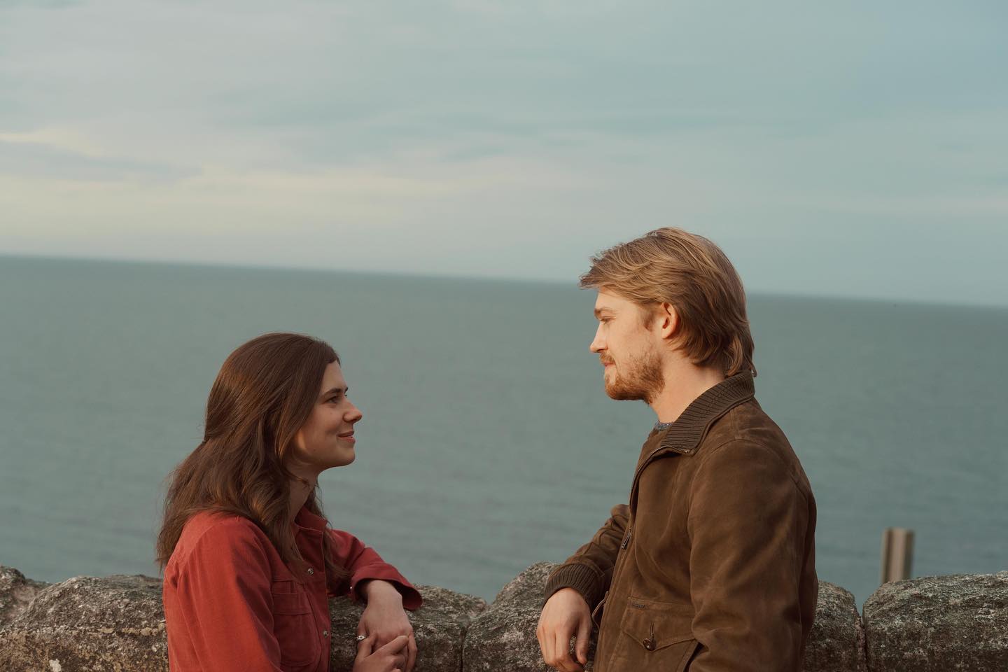 A man and a woman stand infront of the sea