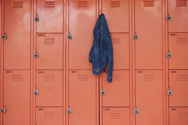 Coral coloured school lockers with a denim jacket hanging off one