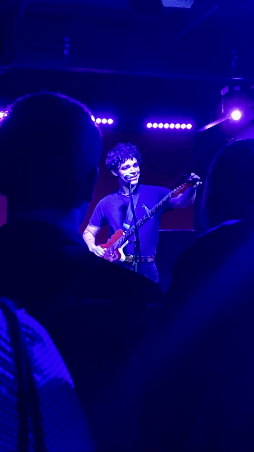 Charlie Hickey smiling with his guitar at his performance