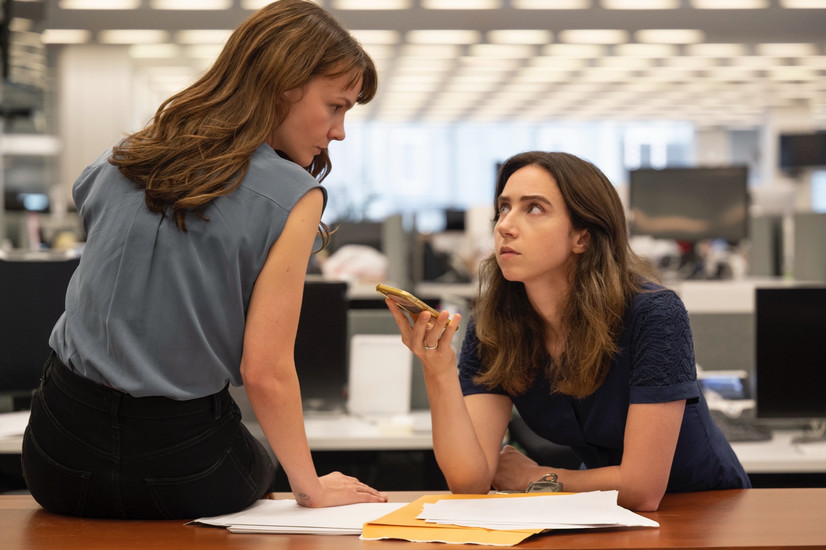 carey mulligan and zoe kazan discuss in an office