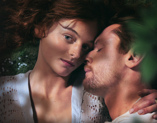 Photo of Emma Corrin and Jack O'Connell lying in a field