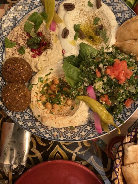 Picture of a plate filled with falafel,hummus and vegetables
