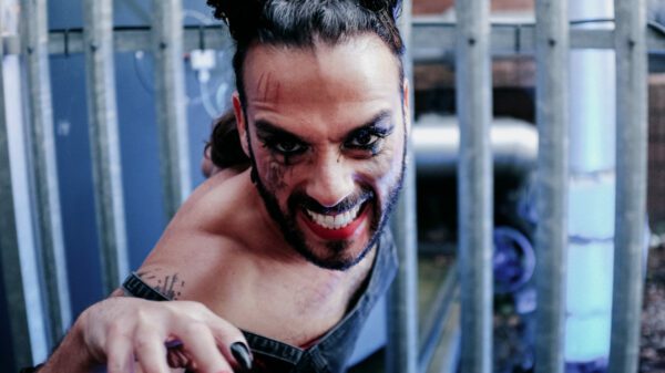 A person with messy makeup and cat scratches grins at the camera