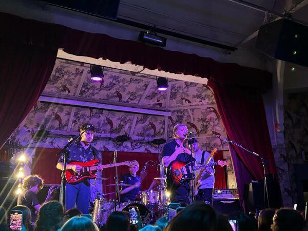 Only The Poets, a four-piece band, perform energetically on stage. 