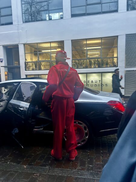 Man in all red outfit outside fashion show 