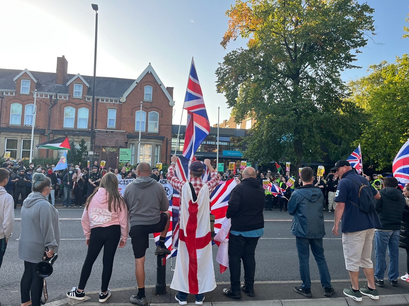Anti-immigration protesters wearing British flags pictured facing counter demonstration on Wilmslow Road.