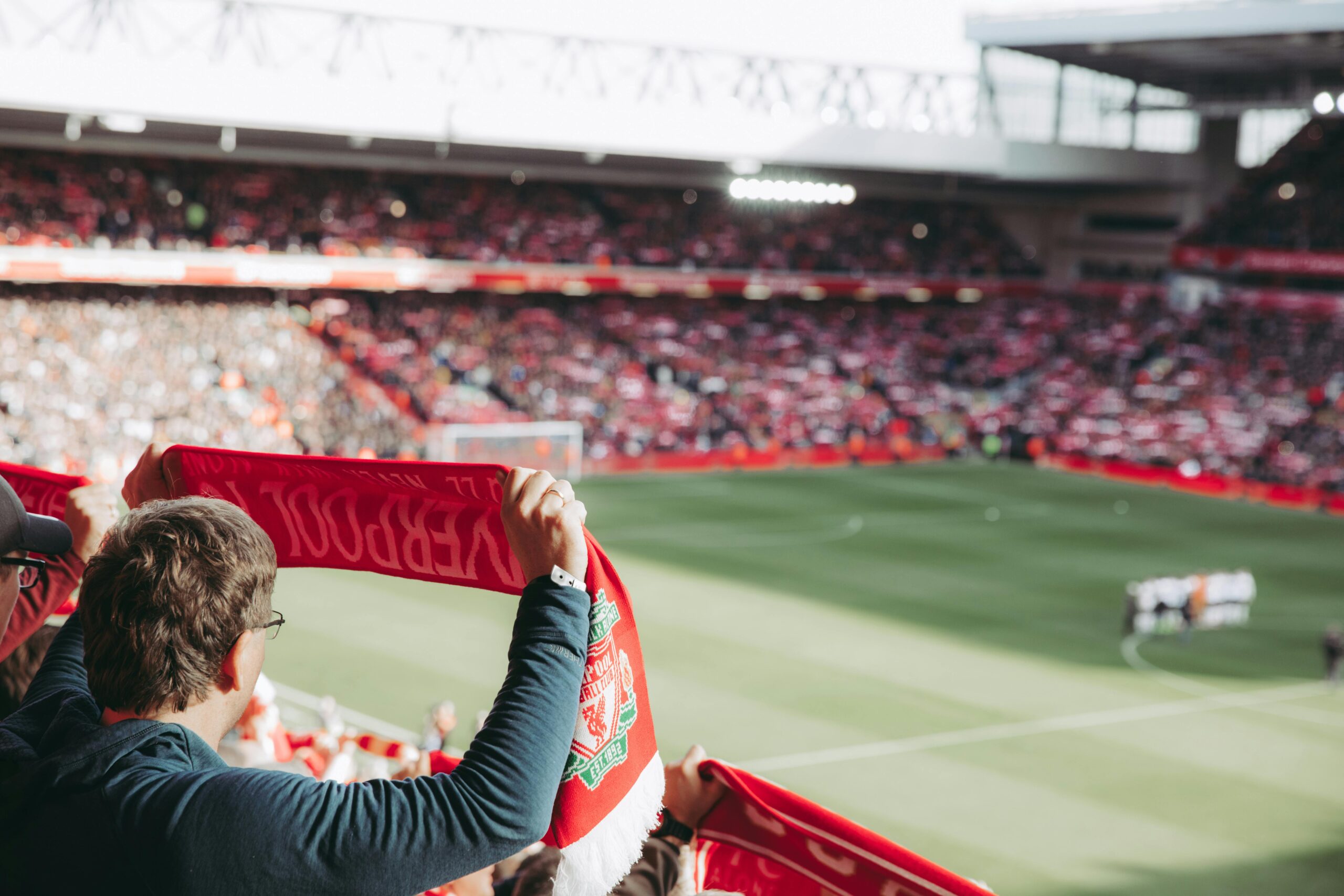 Liverpool fan holds up scarf before match at Anfield.